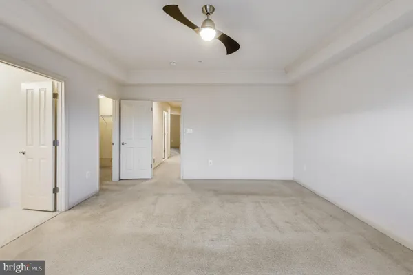 an empty room with fan and windows