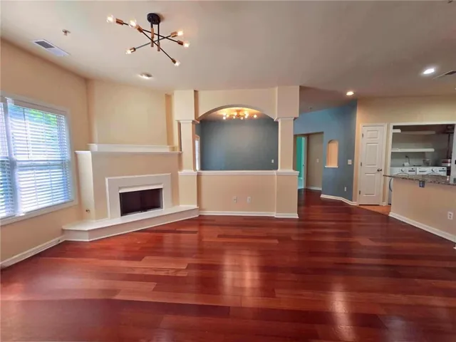 a view of empty room with wooden floor and fireplace