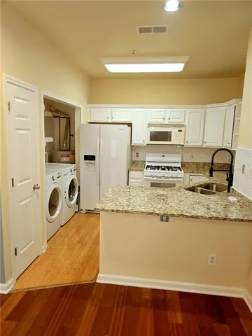 a kitchen with kitchen island granite countertop a sink and refrigerator