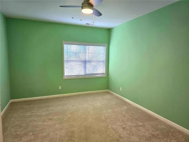 an empty room with closet and windows