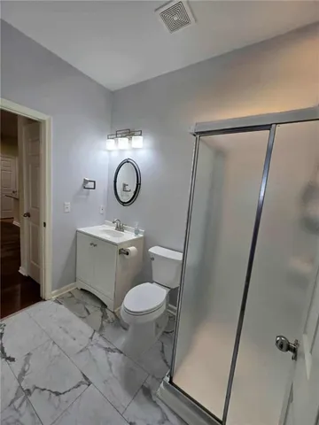 a bathroom with a sink a toilet a mirror and shower