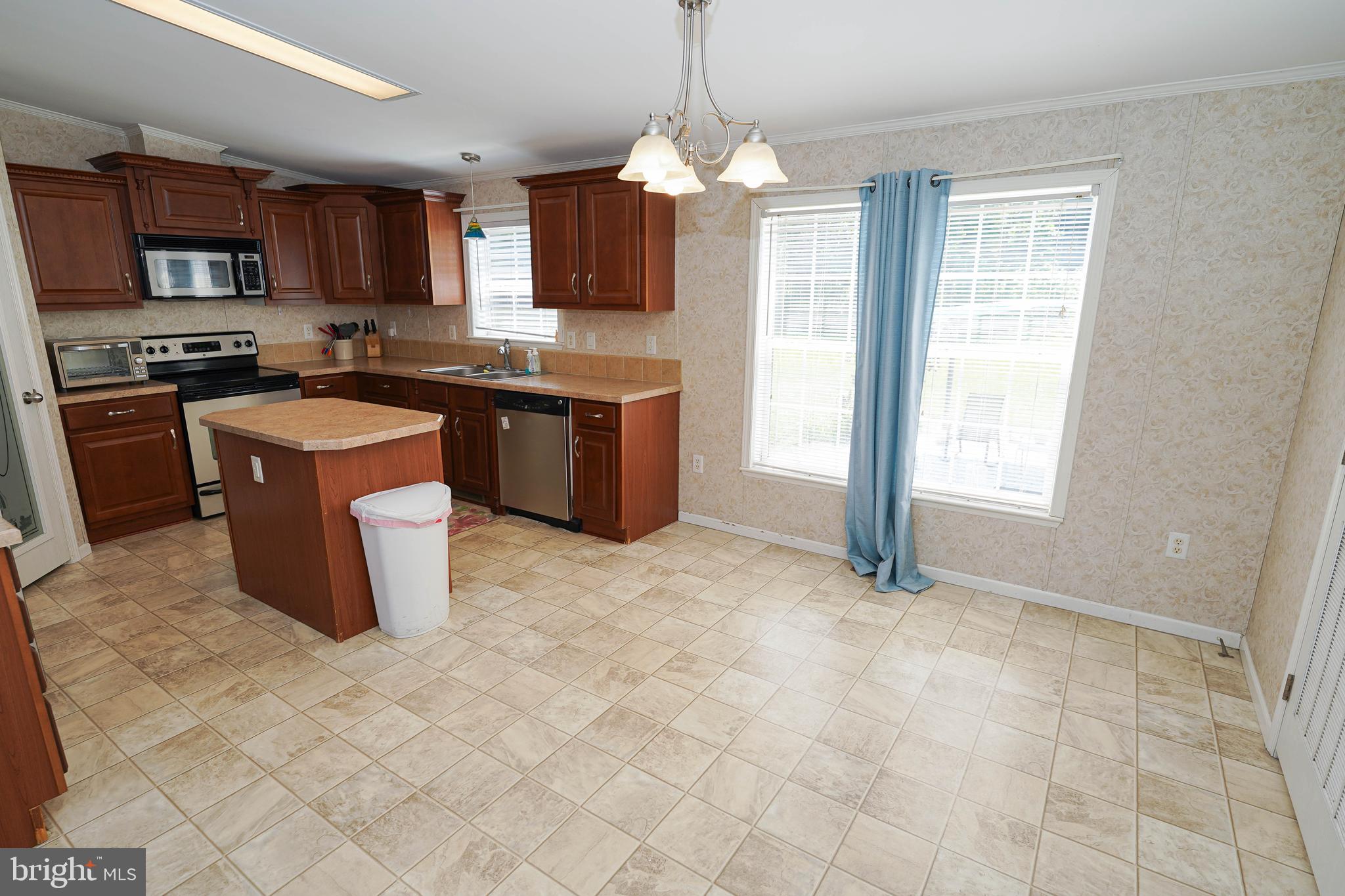 5846 Puckum Road Rhodesdale, MD 21659 - Photo 8 of 32 a kitchen with stainless steel appliances granite countertop a stove top oven a sink a counter top space cabinets and a window