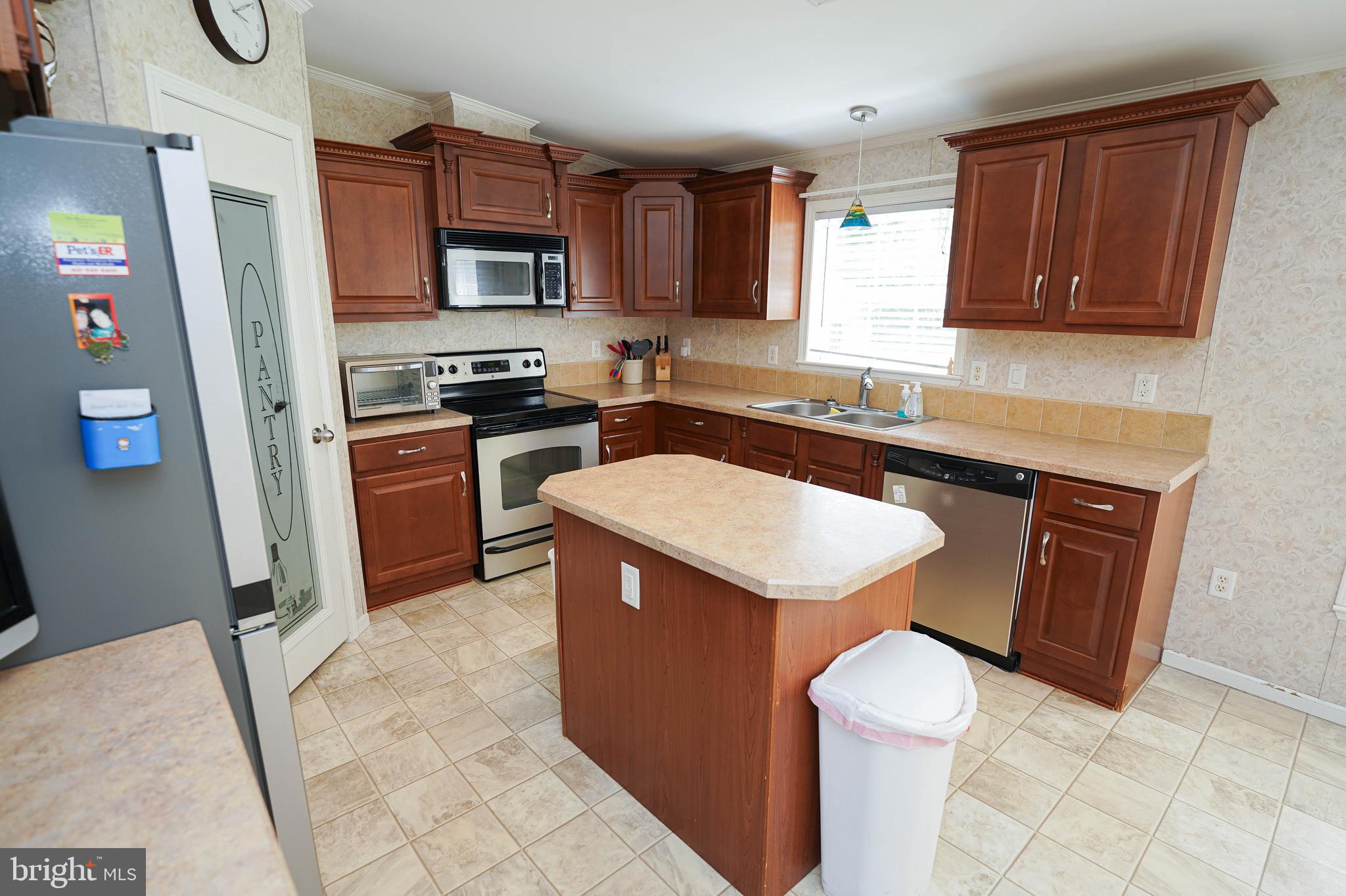 5846 Puckum Road Rhodesdale, MD 21659 - Photo 9 of 32 a kitchen with a sink a stove top oven and cabinetry