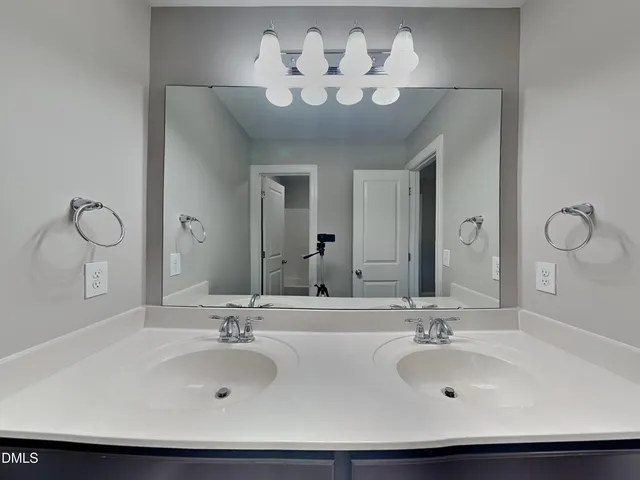 a bathroom with a double vanity sink and a mirror