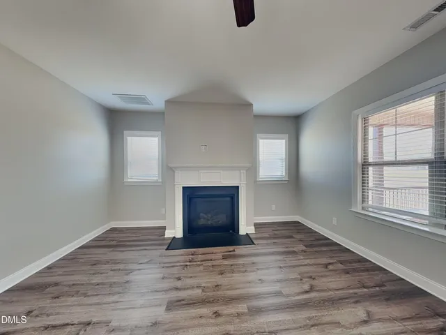 an empty room with windows and a fireplace