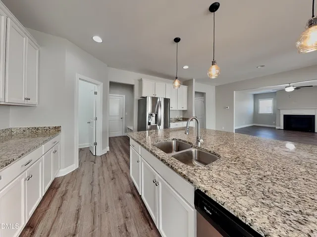 a kitchen with granite countertop a sink a counter top space appliances and cabinets