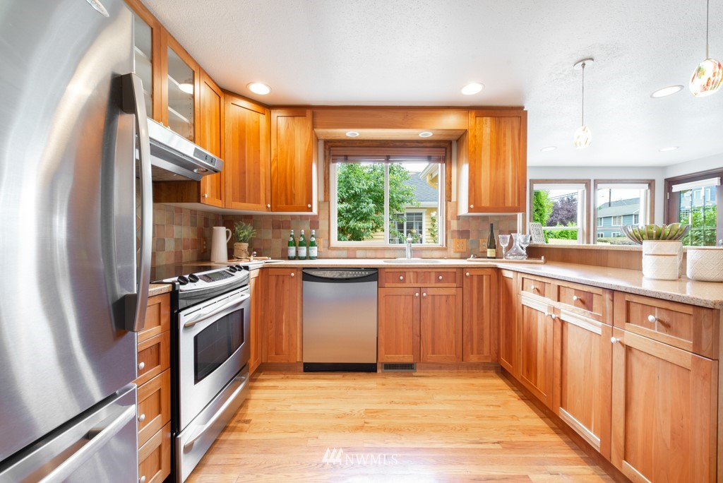 560 North 76th Street Seattle, WA 98103 - Photo 11 of 37 a kitchen with stainless steel appliances granite countertop a stove a sink and a refrigerator