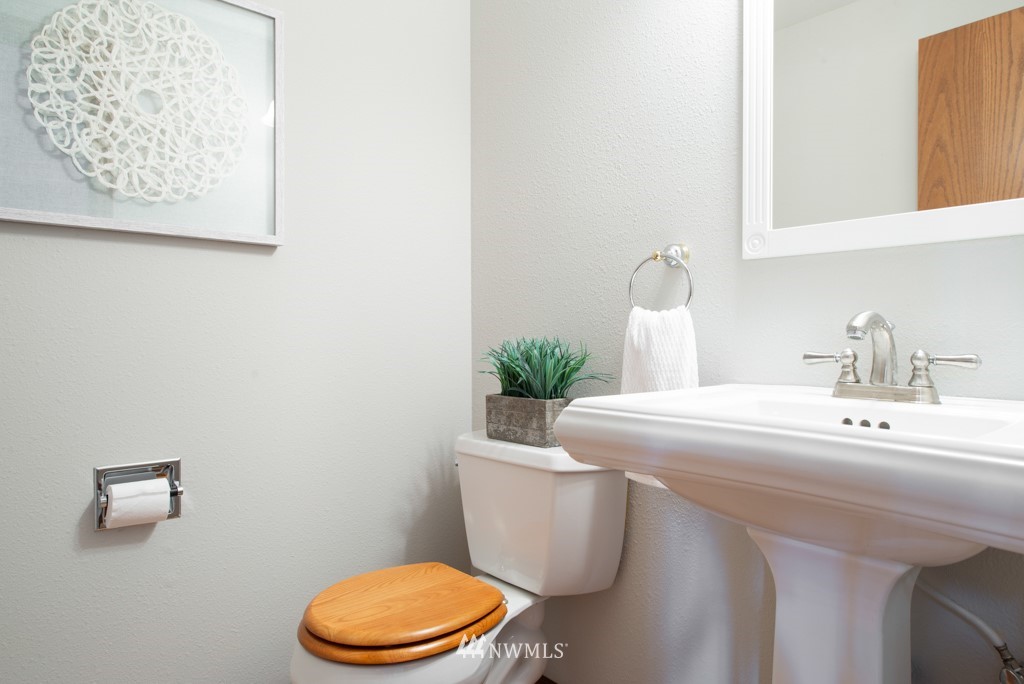 560 North 76th Street Seattle, WA 98103 - Photo 30 of 37 a bathroom with a sink a toilet and a mirror