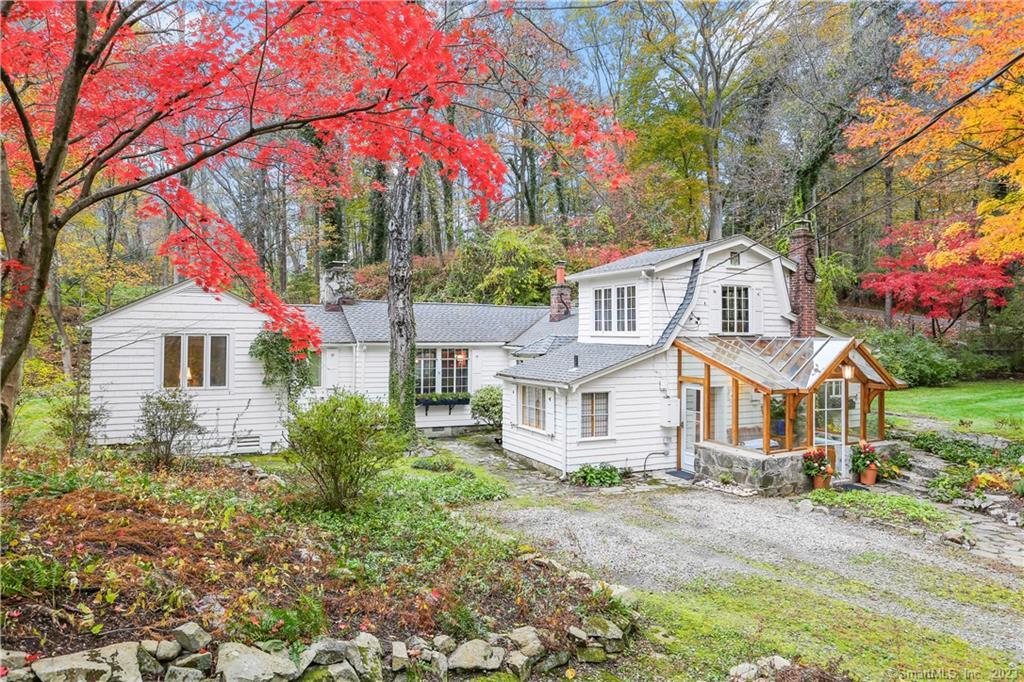 a front view of a house with a yard and tree s