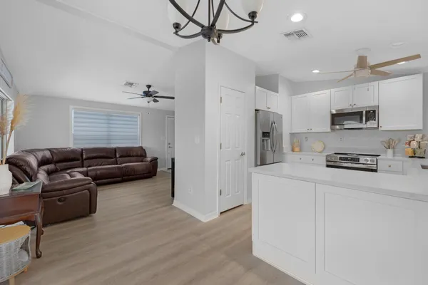 a living room with furniture a couch and kitchen view
