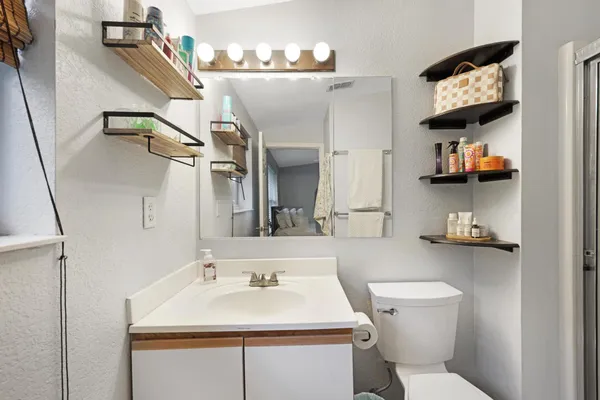 a bathroom with a sink mirror and toilet