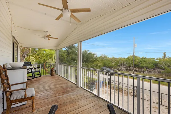 a view of a balcony with chairs and wooden floor