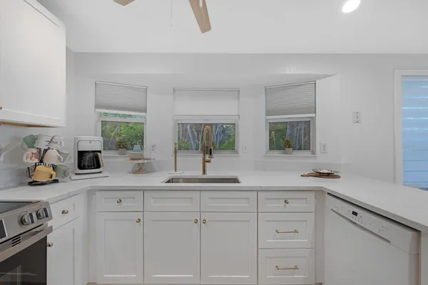 a kitchen with white cabinets and sink