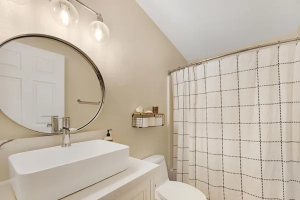 a bathroom with a sink a toilet and mirror