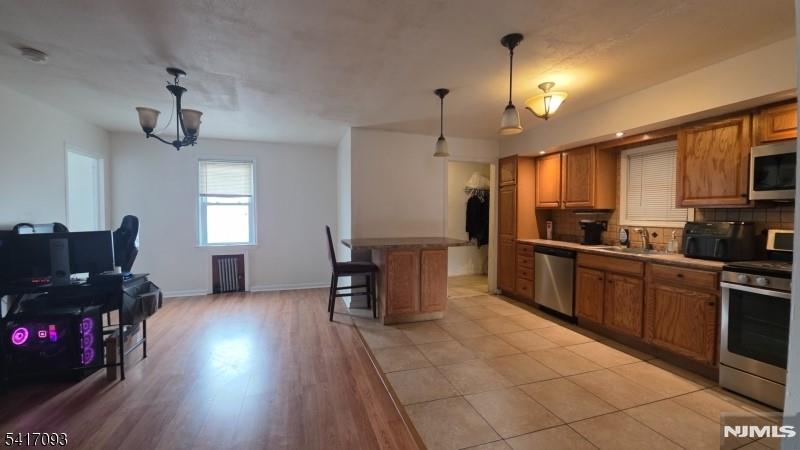 342 Sherman Street Passaic, NJ 07055 - Photo 19 of 32 a kitchen with granite countertop a refrigerator oven a sink a dining table and chairs with wooden floor