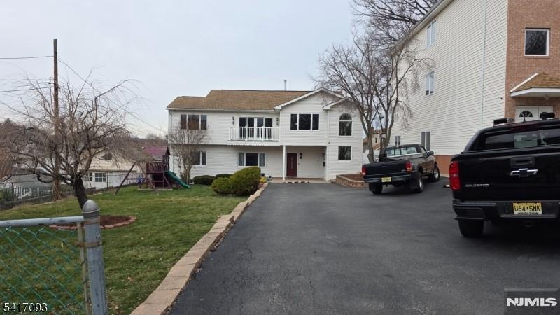 342 Sherman Street Passaic, NJ 07055 - Photo 2 of 32 a view of a white house that has a car parked beside it
