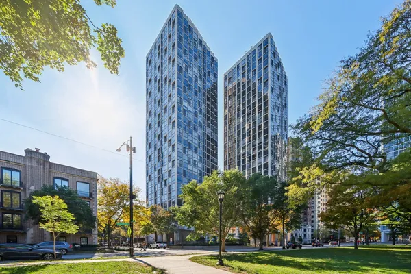a view of a tall building next to a yard