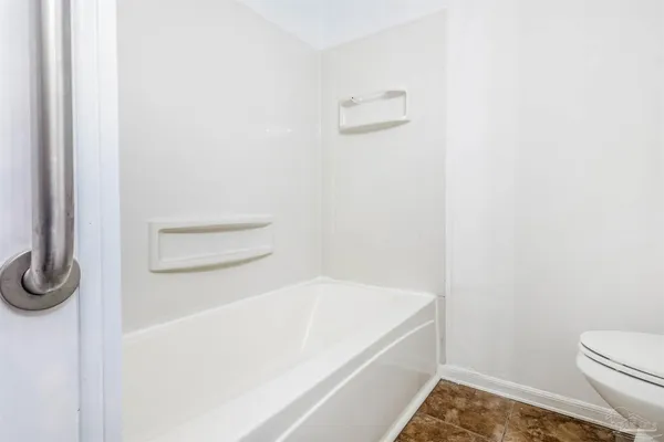 a view of an empty room with a fireplace and a window