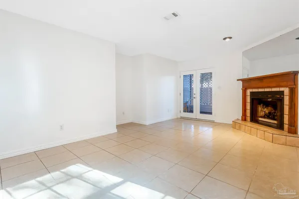 a view of an empty room with window and fire place