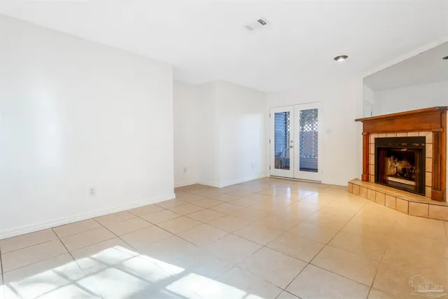 a view of an empty room with window and fire place