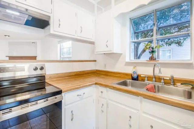 a kitchen with granite countertop a sink stainless steel appliances window and cabinets