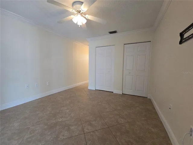an empty room with a ceiling fan and a window