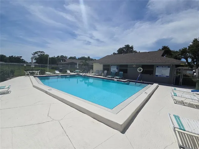 a view of a house with pool and a yard