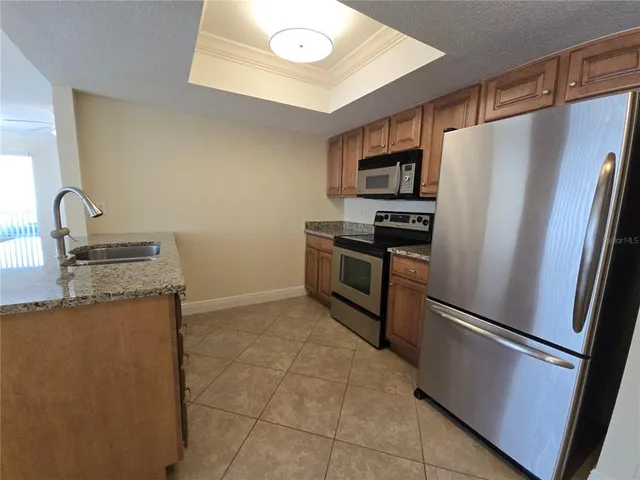 a kitchen with stainless steel appliances granite countertop a refrigerator and a sink