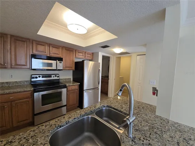a kitchen with a sink and stainless steel appliances