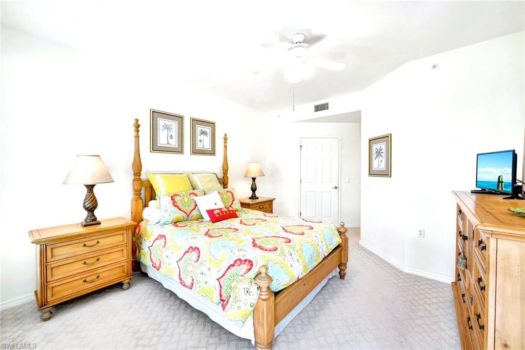 2190 Arielle Drive, Unit 903 Naples, FL 34109 - Photo 12 of 26 a bed room with a bed and a night stand
