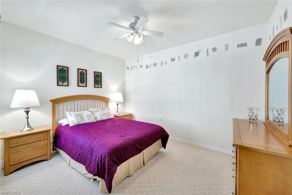 2190 Arielle Drive, Unit 903 Naples, FL 34109 - Photo 14 of 26 a bedroom with a bed and a chandelier