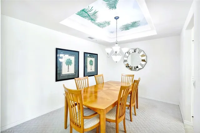 a dining room with furniture a chandelier and wooden floor