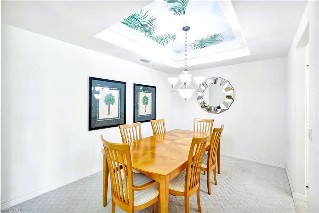 2190 Arielle Drive, Unit 903 Naples, FL 34109 - Photo 8 of 26 a dining room with furniture a chandelier and wooden floor