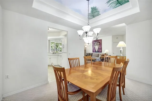 a dining room with wooden floor a chandelier a wooden table and chairs
