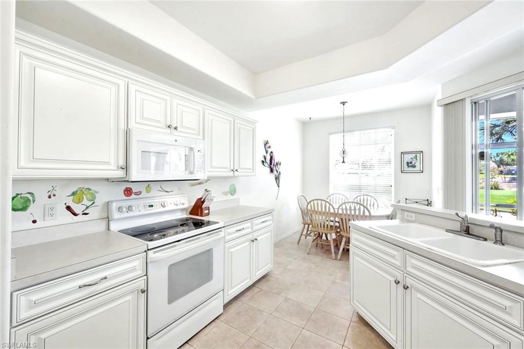 2190 Arielle Drive, Unit 903 Naples, FL 34109 - Photo 10 of 26 a kitchen with a sink stove and cabinets
