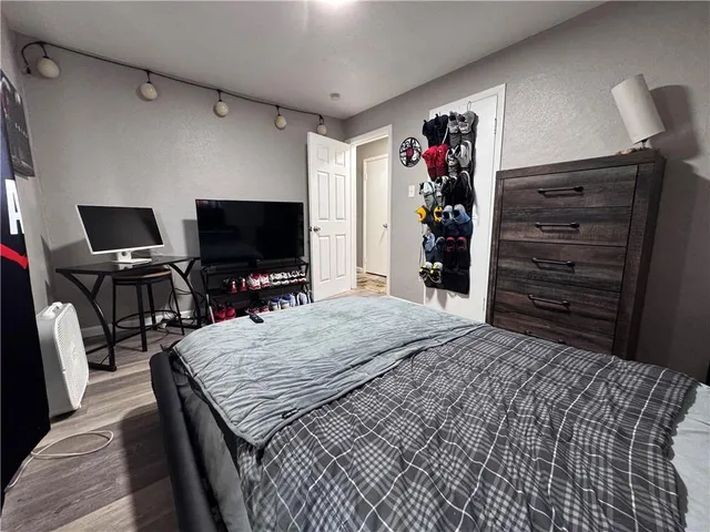 a bedroom with a bed a dresser and a window