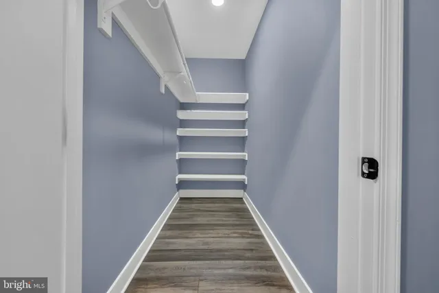 a view of a hallway with wooden floor and entryway