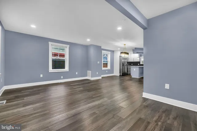 a view of empty room with kitchen and window