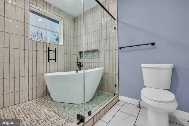 a white tub sitting next to a toilet