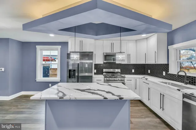 a kitchen with stainless steel appliances kitchen island granite countertop a sink and cabinets