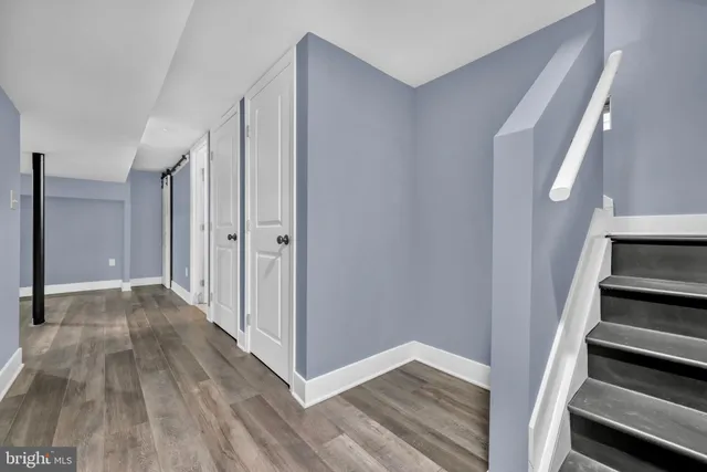 a view of a hallway with wooden floor and entryway