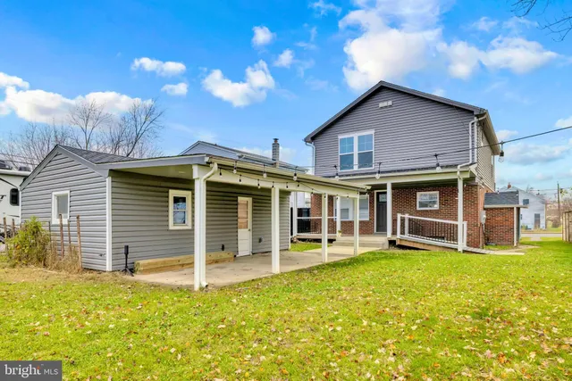 a view of a house with a yard and sitting area