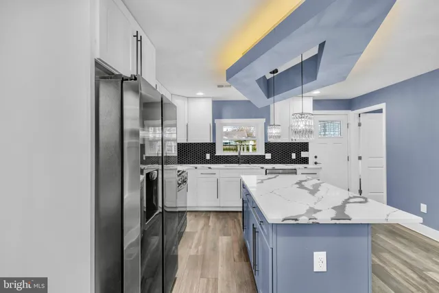 a kitchen with a refrigerator a sink and cabinets