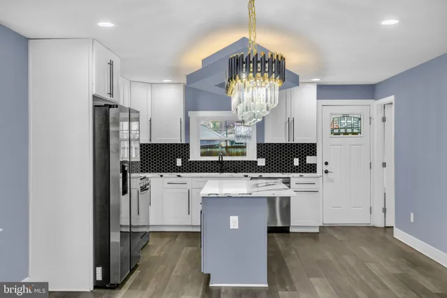 a kitchen with stainless steel appliances a stove refrigerator and chandelier