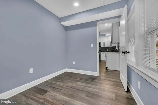 wooden floor in an empty room with a kitchen
