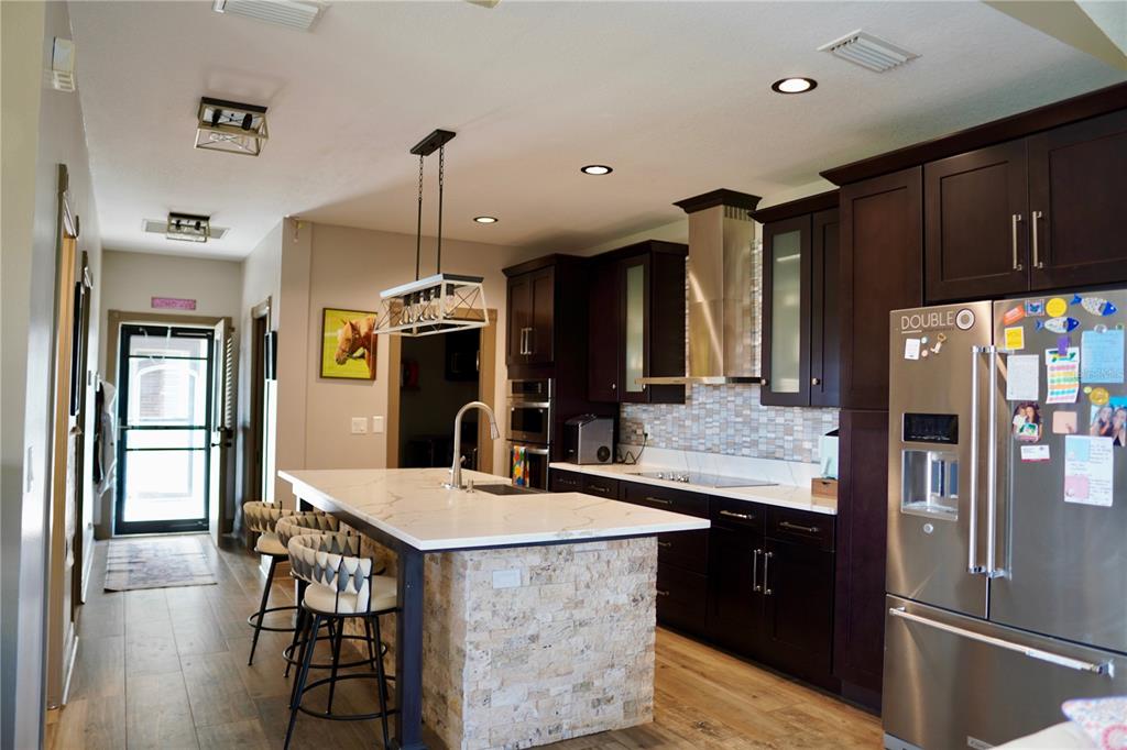 12895 Northwest Gainesville Road Reddick, FL 32686 - Photo 12 of 51 a kitchen with stainless steel appliances kitchen island granite countertop a refrigerator a sink and a stove