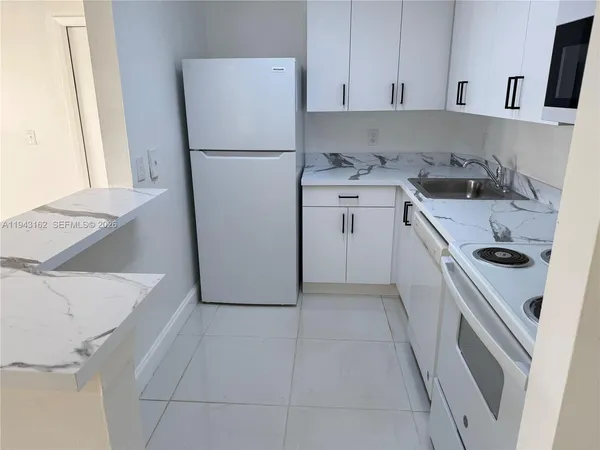 a kitchen with a refrigerator sink stove and cabinets