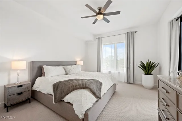 a spacious bedroom with a large bed and a potted plant