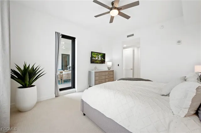 a bedroom with a large bed and potted plant