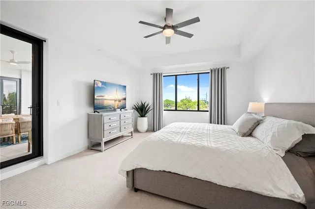 a bedroom with a bed a large window and flat screen tv